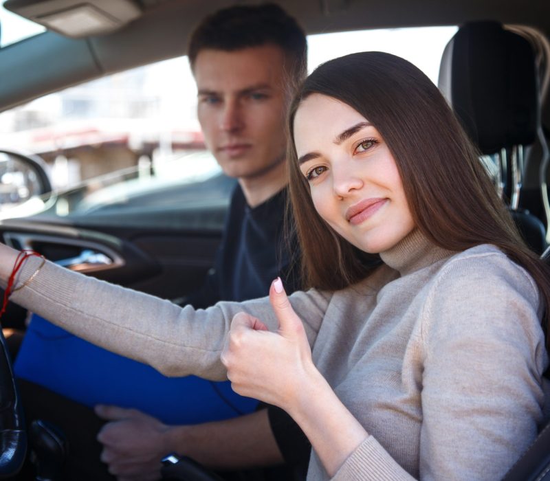 The driver is an auto school instructor and a female student on an examination car. Lesson at the circuit